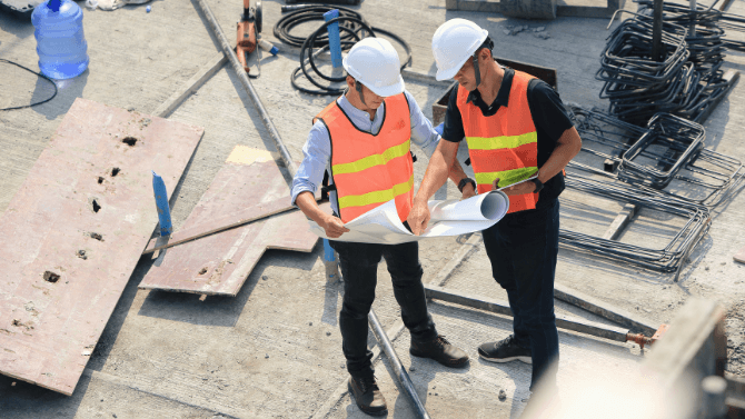 Ingénieurs sur chantier avec des plans