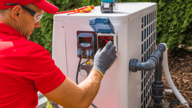 Technicien en train de réparer une thermopompe dans le jardin