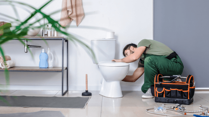 Entrepreneur qui installe une toilette