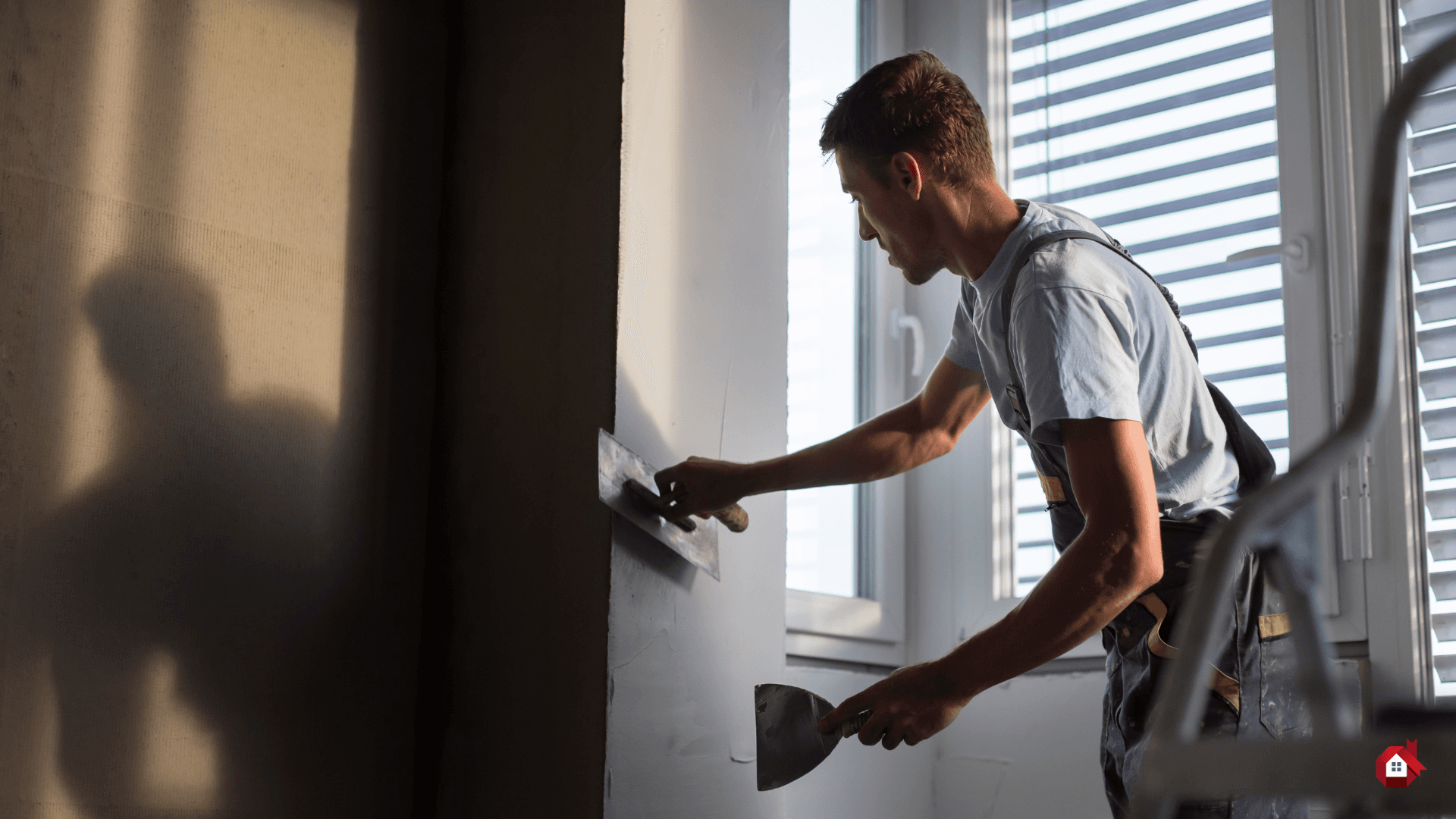 entrepreneur mettant du crépi sur le mur