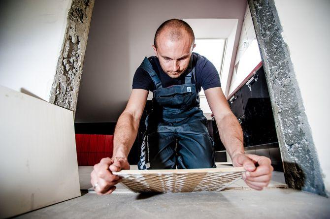 Homme qui pose une tuile de céramique