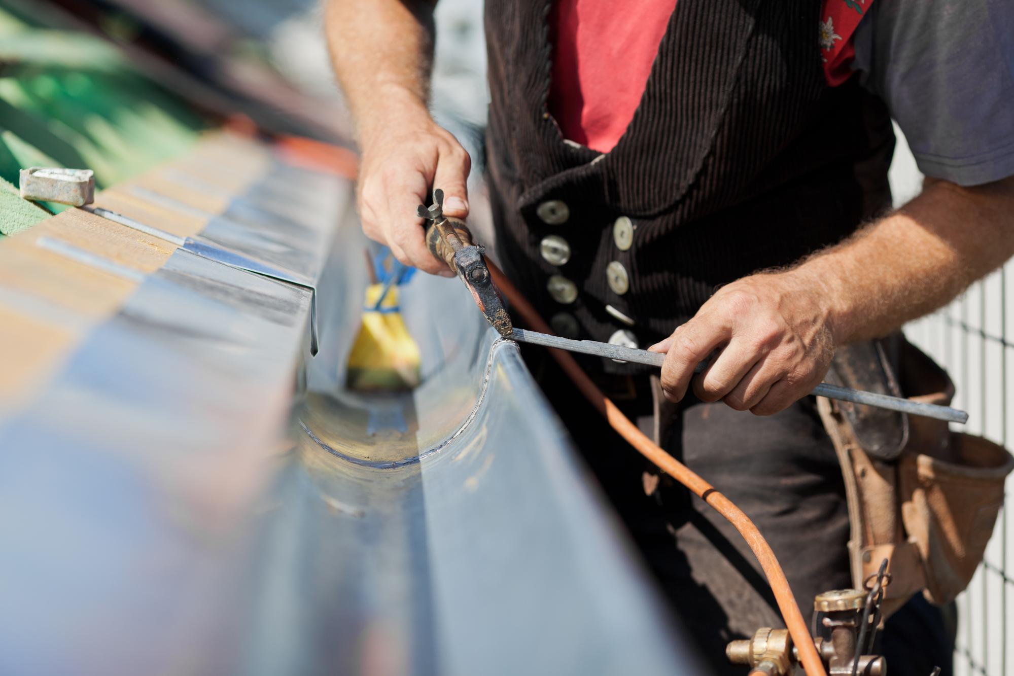 Entrepreneur qui installe gouttières