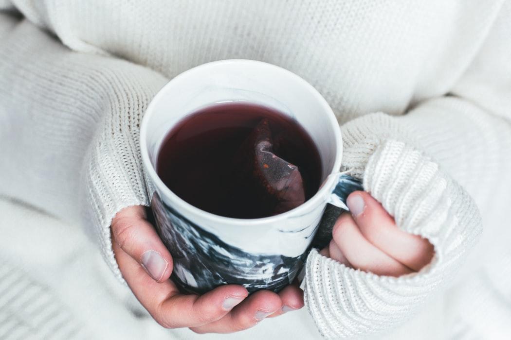 femme tenant une tasse de thé